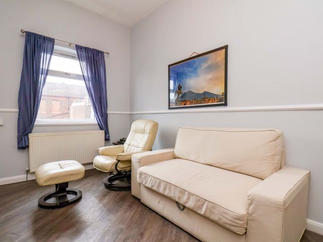 A living room with a sofa and armchair at 122B Norton Road Stockton-on-Tees