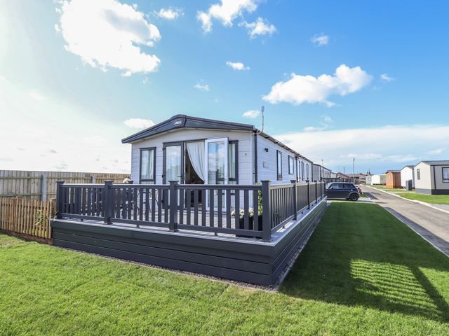 A mobile home with decking at Number 6 - Sandy Beach Holiday Park in Bacton