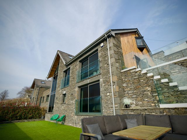 A house with a balcony and outdoor seating at Midways Bowness-On-Windermere