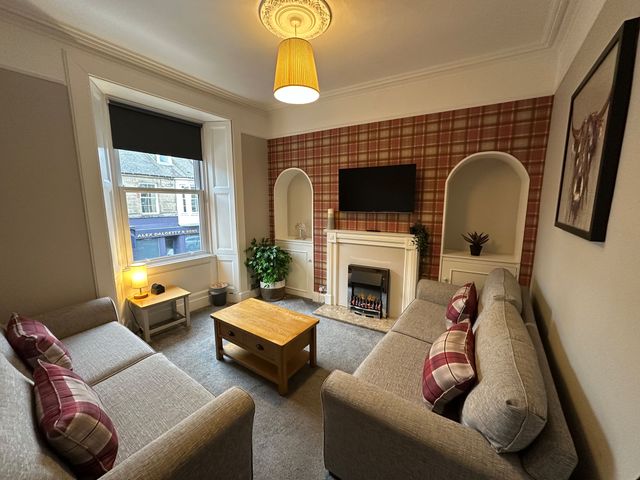 A living room with sofas, a coffee table and a fireplace at The Teviot in Kelso