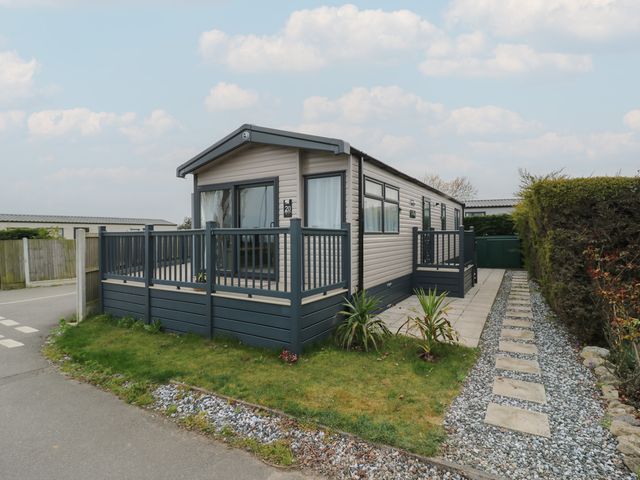 A mobile home with a deck and gravel path at no 20 Barley Way in Colchester