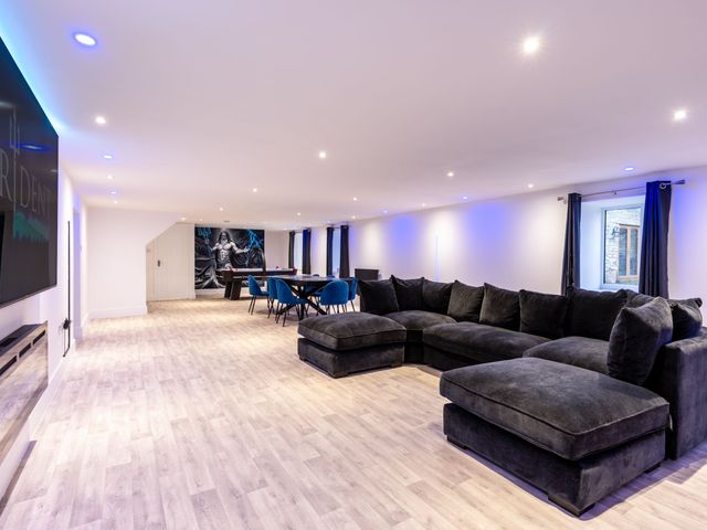 A living room with a large sofa and dining table at Manor Farm in Glastonbury