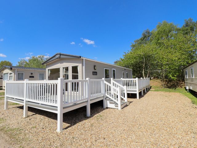 A mobile home with a deck and steps at 39 Larch View with hot tub Tattershall