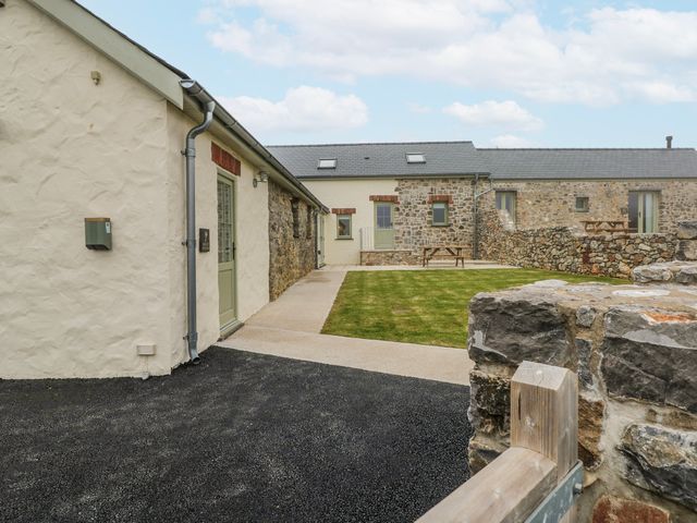 An outdoor view of buildings and lawn at Barley Cottage Oxwich