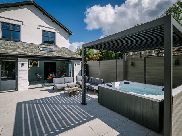 An outdoor area with a hot tub and seating at Bounty Boutique on the Lakes, Bowness-On-Windermere
