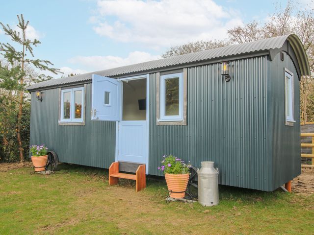 A shelter with blue door and windows set outside at Skye in Clee Hill