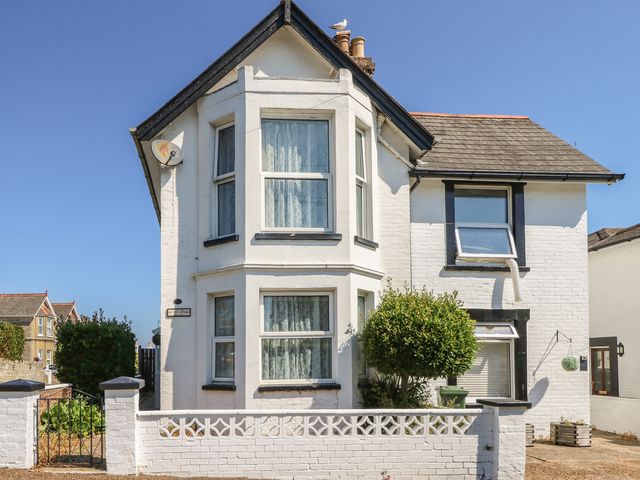 A house with a satellite dish and a bush at Bay Tree Cottage in Shanklin