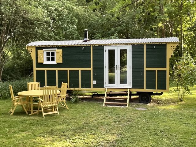 A shepherd hut with steps and garden furniture at The Shepherds Hut in Wallingford