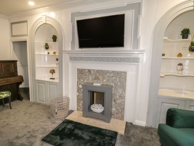A living room with a fireplace and television at 47 Baxtergate in Whitby