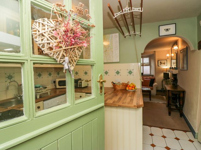 A kitchen with a door and a wicker heart decoration at Corner Cottage in Lowick Green near Ulverston