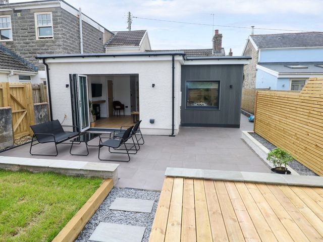 An outdoor patio with chairs and a table at Y Bwthyn Burry Port