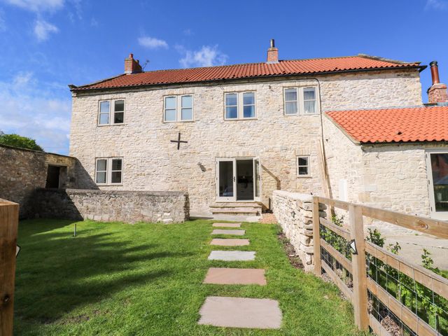 A stone house with windows and a door in Tadcaster at Stewards House