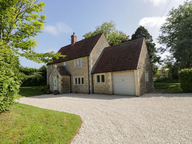 A house with a garage and trees surrounding at The Paddocks in Chippenham