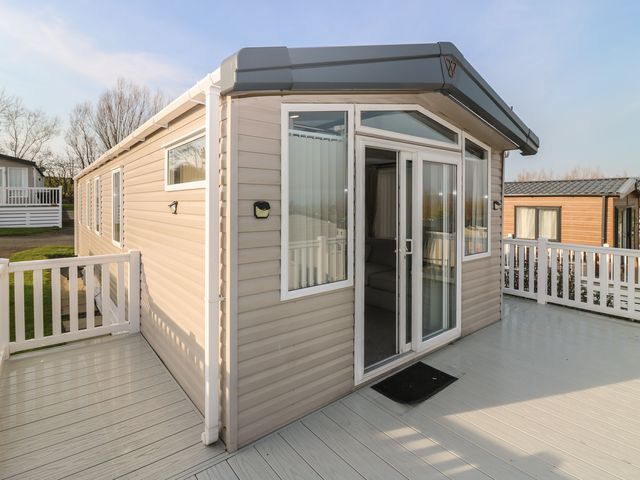 A mobile home with a deck and glass door at Plot 243 - Coldingham Bay Leisure Park, Eyemouth