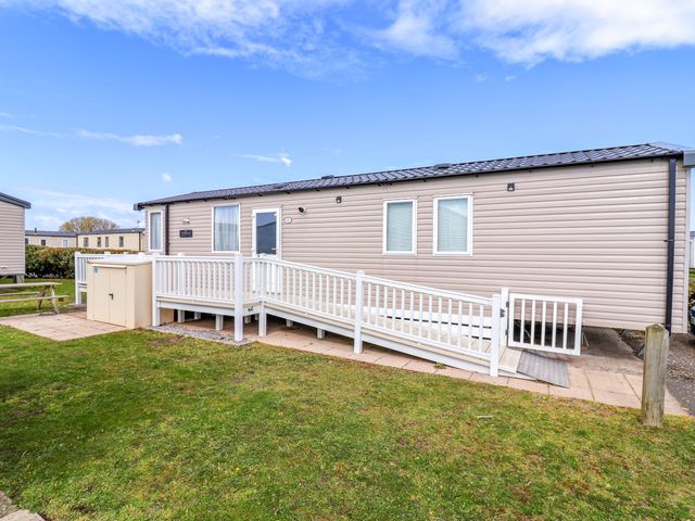 A mobile home with a deck and ramp at The Retreat in Prestatyn