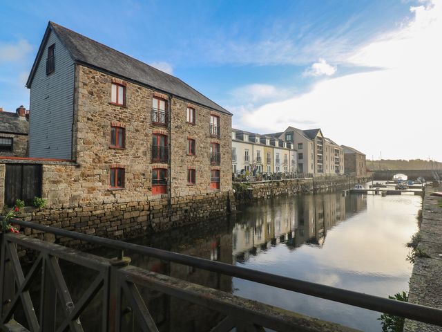 A waterfront scene featuring buildings and boats at Apartment 6 Penryn