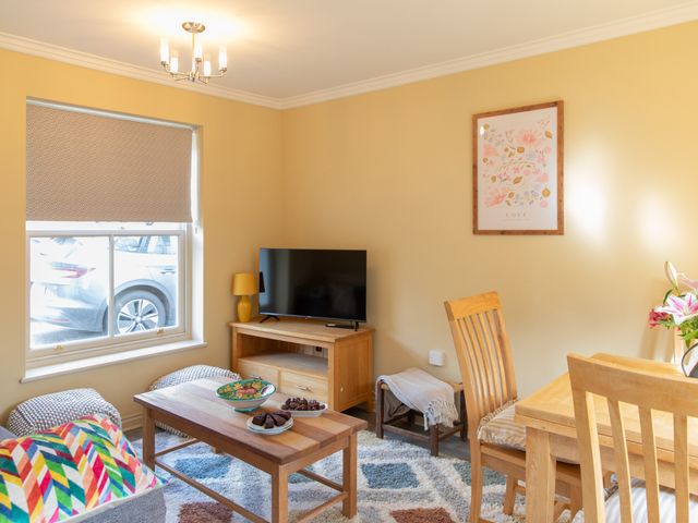 A living room with a television and table at Sheriff's Tower Cottage - West, Bishop Auckland