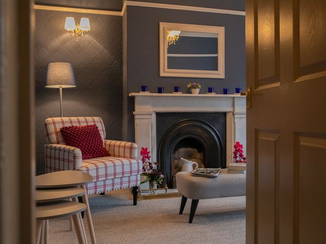 A living room with a fireplace and armchair at No 2 Townhouse in Bishop Auckland
