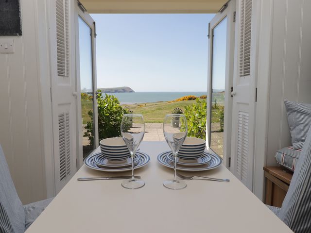 A dining area with a table set for two with a view of the sea at The Bolthole Newport