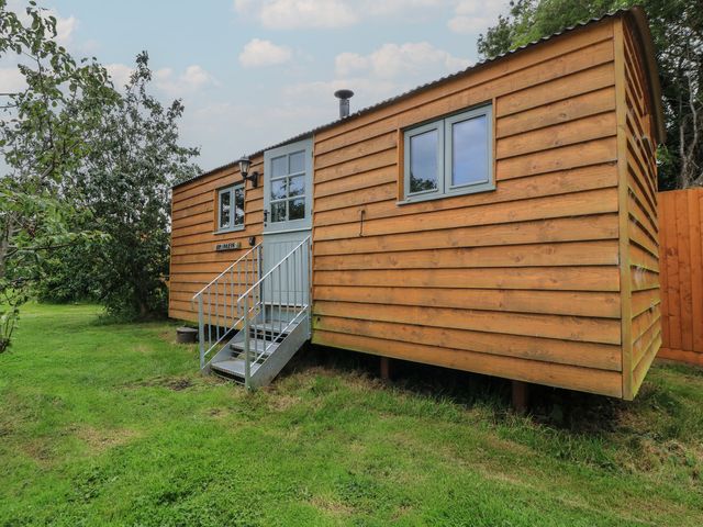 A wooden cabin with stairs and windows in a garden at Bramleys in Williton