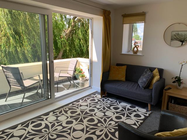 A living room with a sofa and chairs at Balcony Apartment near Skegness Beach & Town Skegness