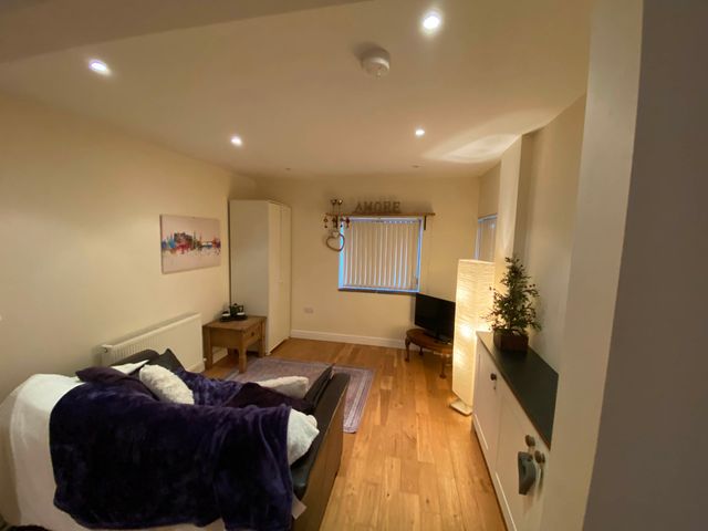 A living room with a sofa and a television at Cosy stable conversion between Sheffield & Leeds Pontefract