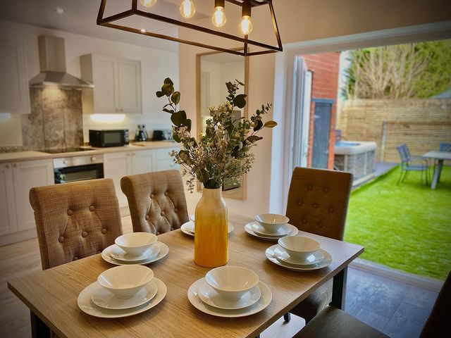 A dining room with a table set at Family modern 3 bedroom hot tub house in Blackpool