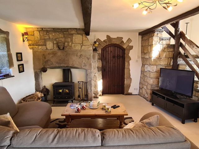 A living room with a coffee table and wood stove at 3 bedroom- Sleeps 6-Greave Farm Todmorden Cottage in Todmorden