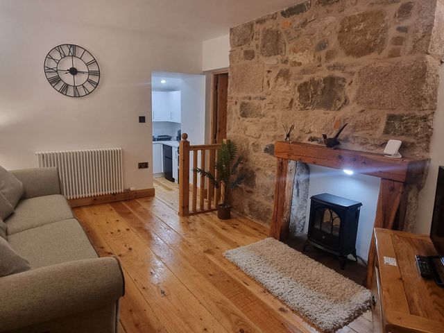 A living room with a sofa and a fireplace at The Coal Office, Aberlour