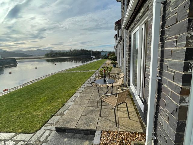 An outdoor area with a table and chairs by the water at 10 Oakley Wharf in Porthmadog
