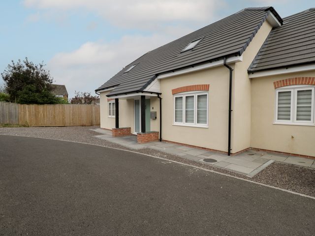An exterior view of a house with a pathway and windows at 1 Brunel Court