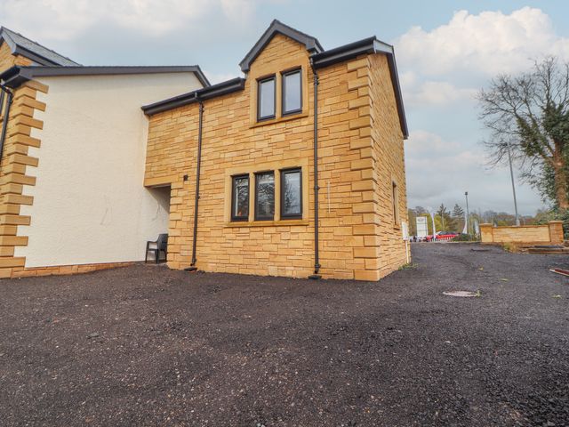 A house with multiple windows and a chair at The Gate House Annexe in Cockermouth