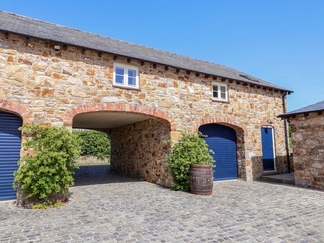 An outdoor area featuring a stone wall and blue doors at Pen Y Grisiau in Mold