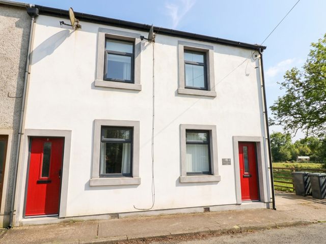A building exterior with windows and red doors at Tethera in Ennerdale