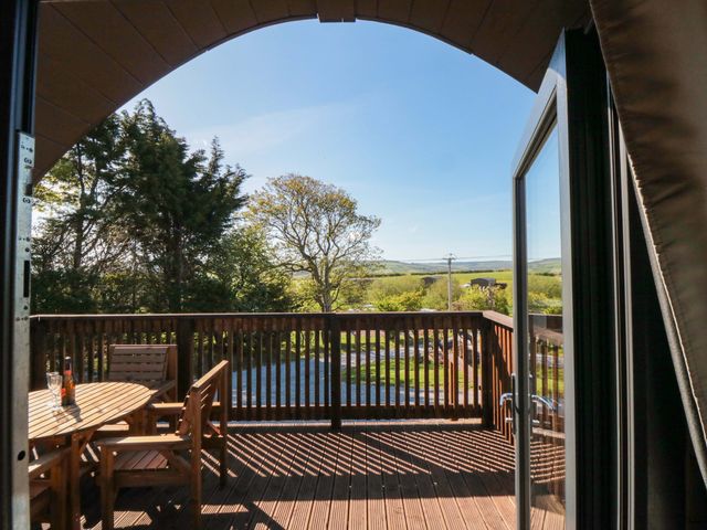 A deck with wooden furniture and view of trees at Rosemary Retreat in Whitby
