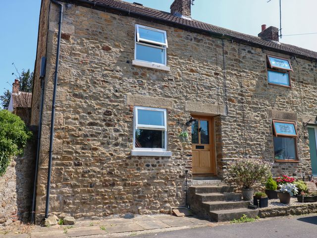 A stone house exterior with a front door and windows at 14 The Porch Barton