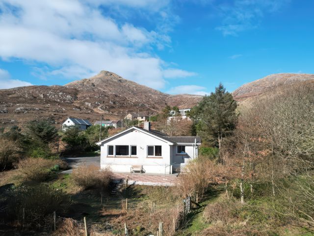 A house with a mountain backdrop at Woodview in Isle of Barra