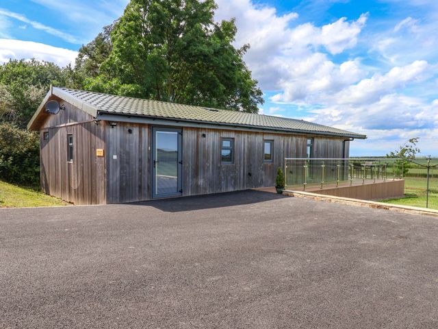 A wooden building with a deck at Freedom Lodge @ Summerfield Farm Whitby