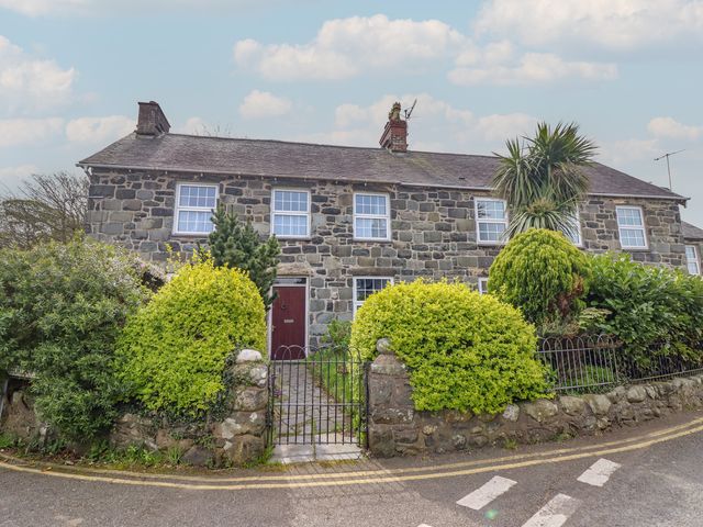 A house with a stone wall and garden at Glanrafon 