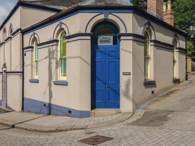 An exterior view of a building with a blue door and windows at Farthings, The Old Chapel in St. Austell