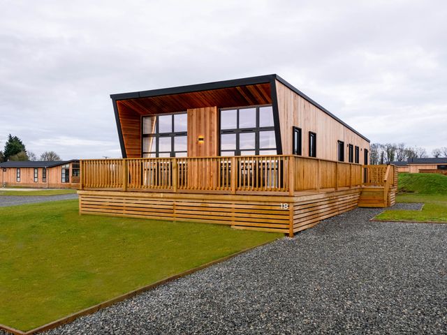 A lodge with decking and large windows at Exclusive Tempest Spa in Grimsby