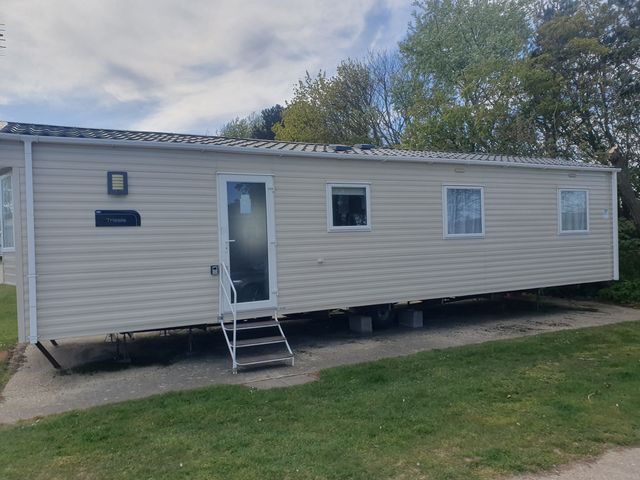 A caravan with a door and windows at Caravan 325 in Lowestoft