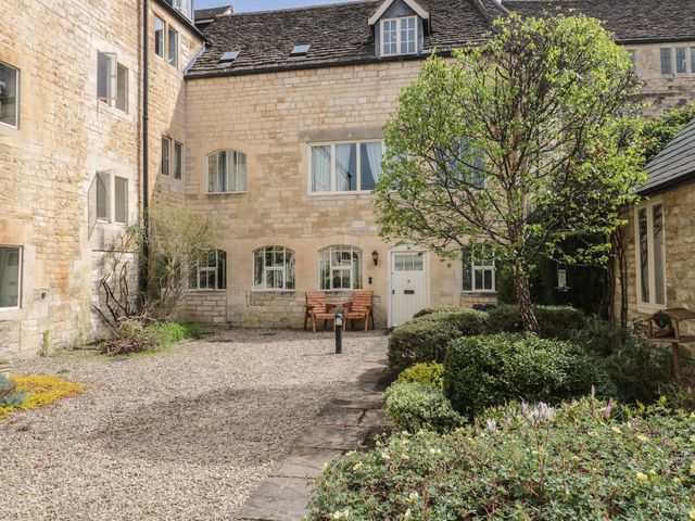 An outdoor area with stone walls and a bench at Longfords Mill near Nailsworth