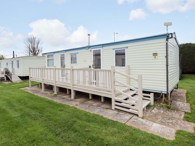 A caravan with decking and steps at Number 9 in Skegness