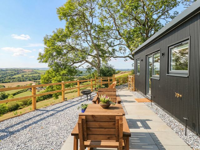 An outdoor seating area with tables and chairs at Little Folley in Whitestone near Tedburn St Mary
