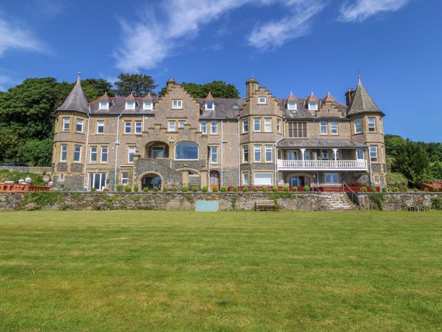 A large building with a lawn and trees at Apartment 1, Bryn Mel Manor in Menai Bridge
