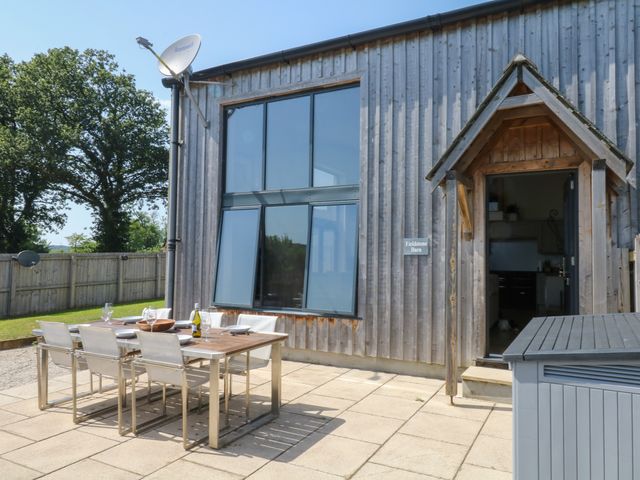 An outdoor dining area with a table and chairs at Fieldstone Barn in North Tawton
