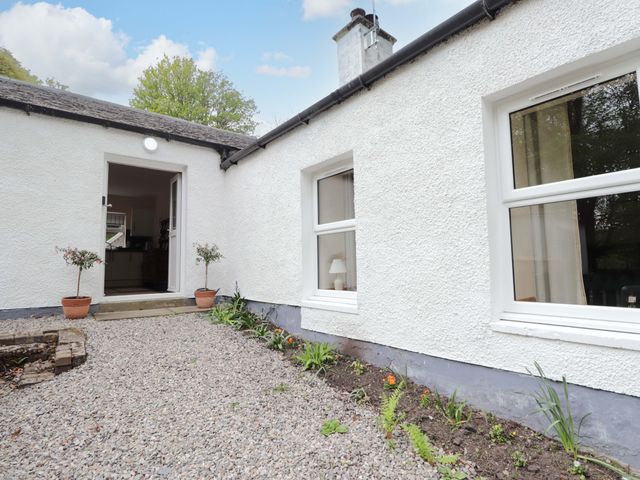 An outdoor area with a door and windows at Laundry Cottage Strathpeffer