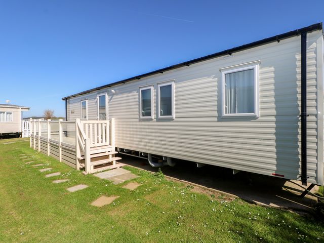 A mobile home with a deck and steps at Seaside Retreat in Selsey