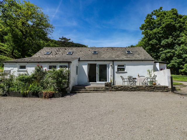 A cottage with a table and chairs at Daffodil Cottage in Blaencwm near Treorchy